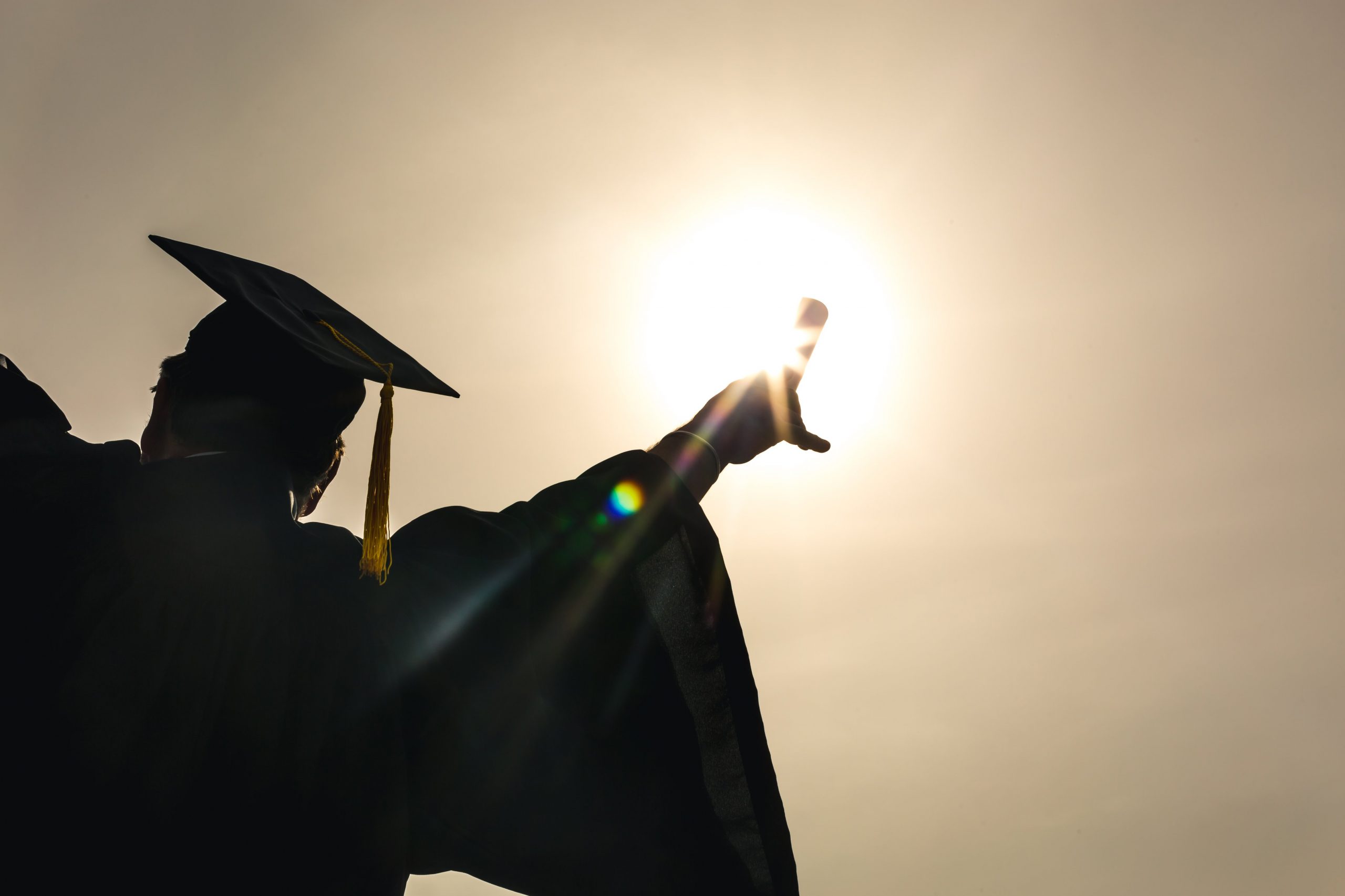 grad_student_celebrating_diploma_up_in_sun-scaled